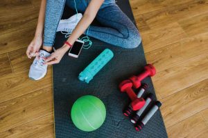 woman on yoga mat with exercise equipment